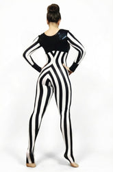A person wearing a Black and White Striped Jumpsuit with a round neck and full sleeves stands with hands on hips, facing away.