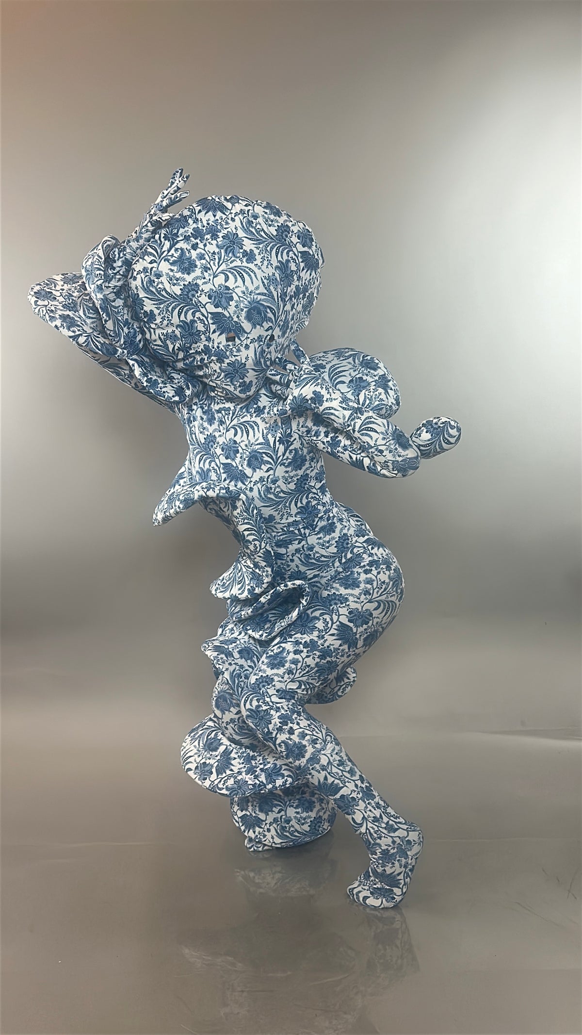 A figure clad in the Mushroom Creature Costume, an avant-garde full body suit featuring a marble print and custom fit, stands against a gray background.