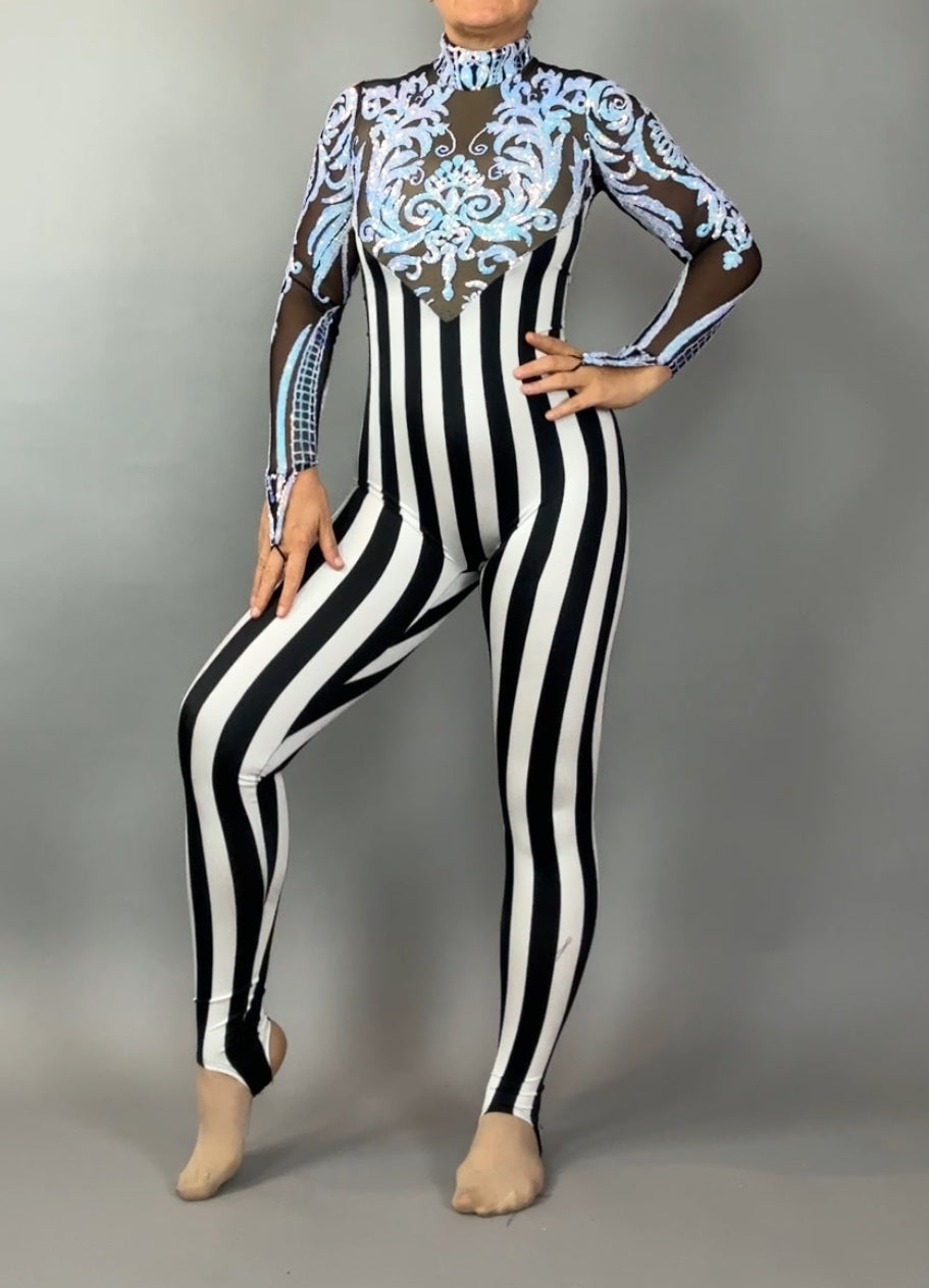 Person wearing the Glamorous sequins Stripes Catsuit costume, featuring black-and-white stripes, sheer sleeves, and blue ornate chest detailing.
