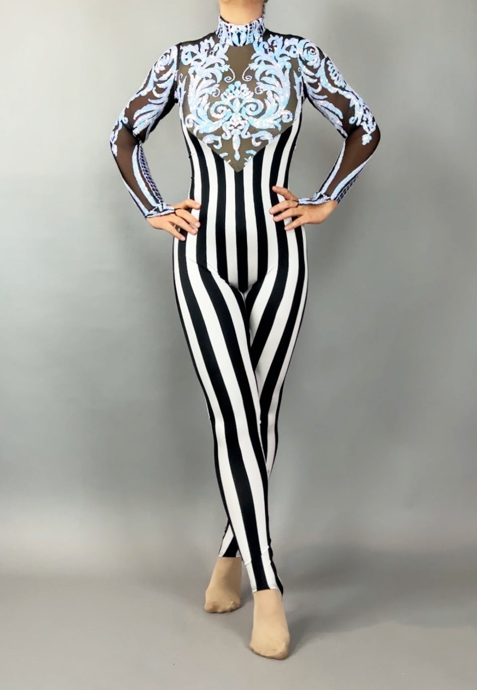 Wearing the Glamorous sequins Stripes Catsuit costume, this person sports black-and-white stripes, sheer sleeves, ornate blue chest detailing, and a sparkling sequined leaf accent.