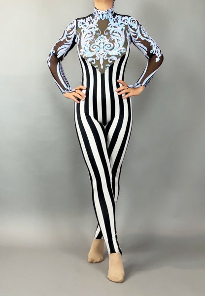 Wearing the Glamorous sequins Stripes Catsuit costume, this person sports black-and-white stripes, sheer sleeves, ornate blue chest detailing, and a sparkling sequined leaf accent.
