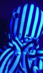 A person in a Black and White Striped Creature Costume with Sculptural Details, featuring a rounded mask and claws.