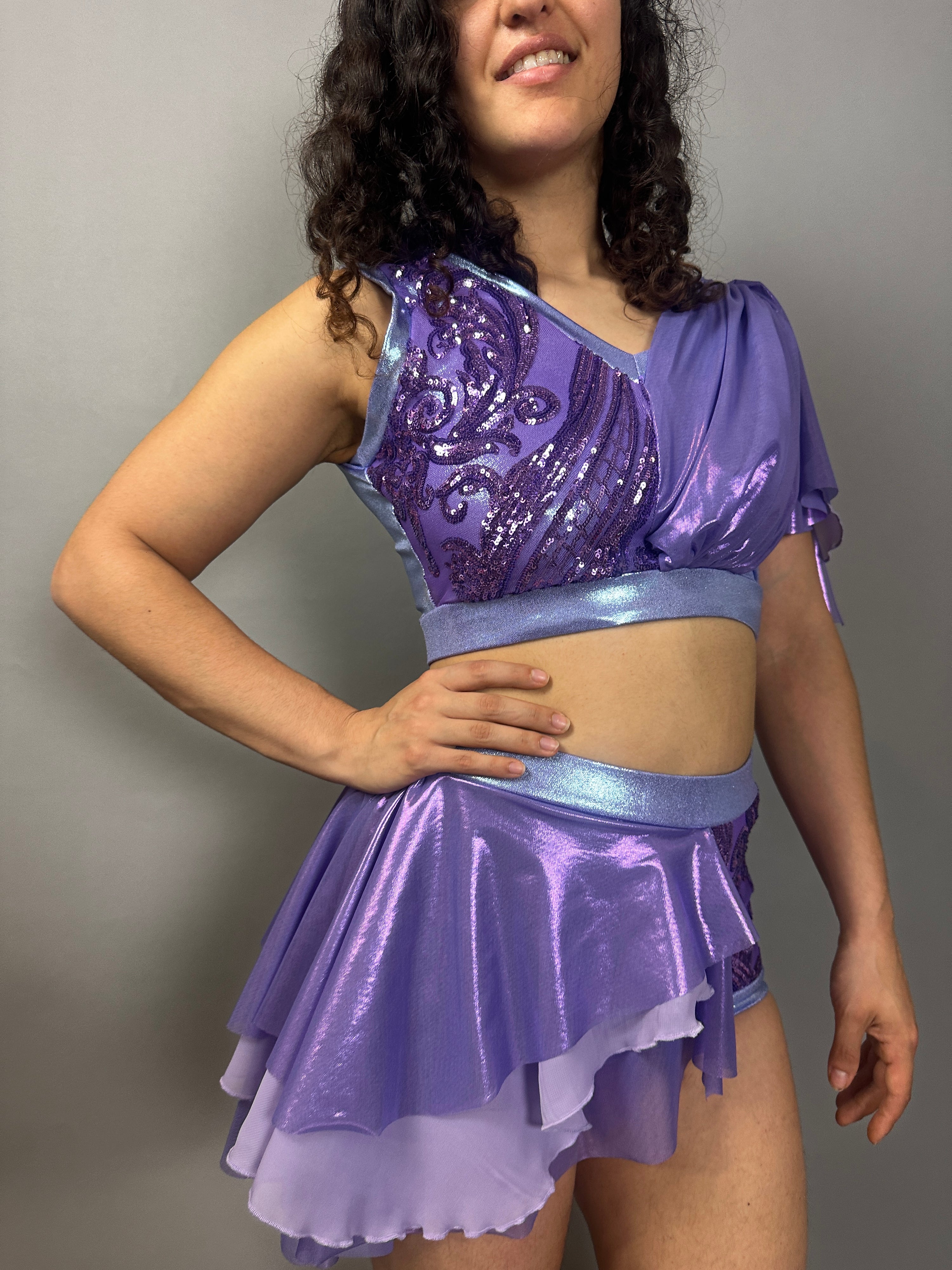 Woman wearing a Lavender Purple Sequin Dance Costume featuring a crop top, high waist shorts with half skirt, and 4-way stretch mesh—ideal as a custom Fire Dancer outfit.
