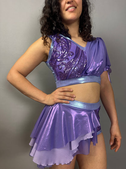 Woman wearing a Lavender Purple Sequin Dance Costume featuring a crop top, high waist shorts with half skirt, and 4-way stretch mesh—ideal as a custom Fire Dancer outfit.