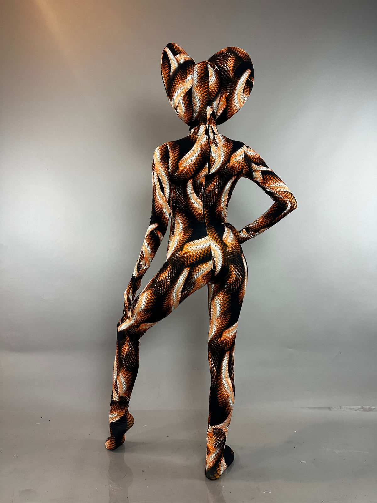 A person wearing a Brown Cobra Costume with a snake-print catsuit and a wide, cobra-shaped headpiece.