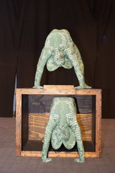 Two performers in Green Pixel Cobra Costumes—snake print catsuits with headdress—pose on and inside a wooden box, their serpent cosplay creating a striking visual against the dark background.