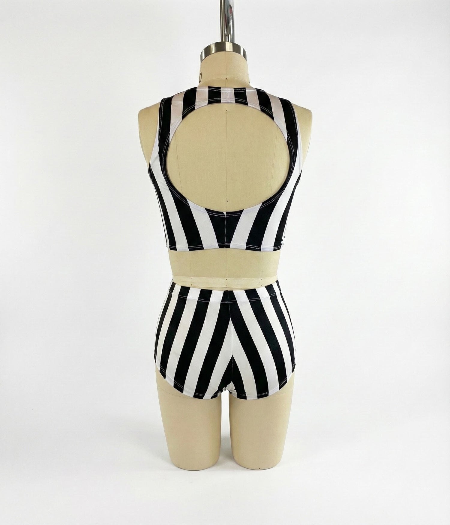 A mannequin wears the Exotic Dance Costume—black and white striped crop top with high-waisted bikini bottoms—shown from the back, perfect as a trending festival outfit.