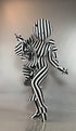 A person in a Black and White Striped Creature Costume with Sculptural Details featuring a round head and ruffles.