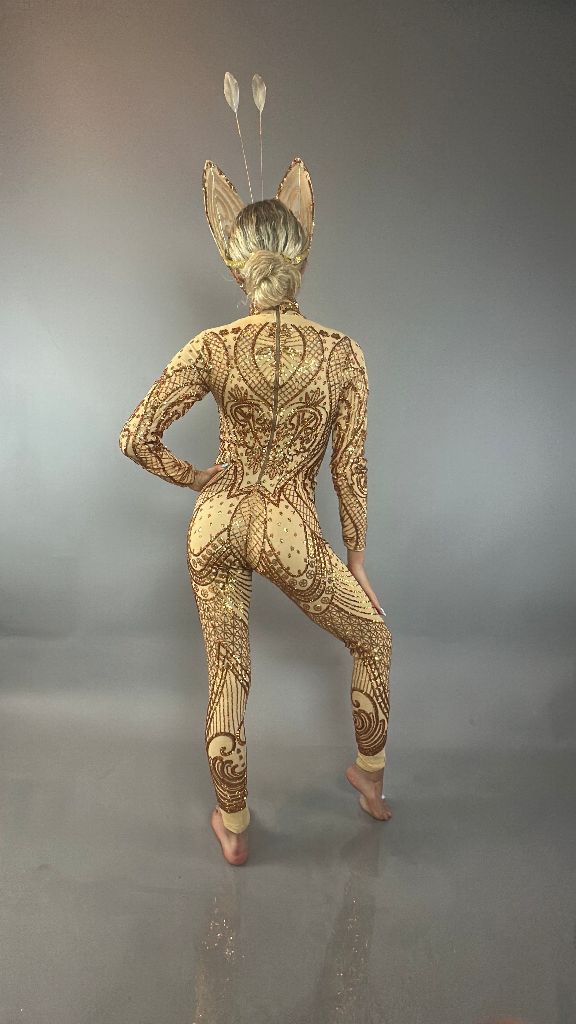 A barefoot model faces away against a plain background, wearing the Golden Butterfly sparkling Sequin full costume with detailed bodysuit, headpiece with antennae, and butterfly wings.