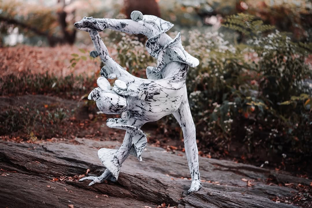 A person in a Mushroom fungus Costume performs an acrobatic handstand on a rocky outdoor surface, showcasing this trending, futuristic fashion and artistic exotic dance wear.