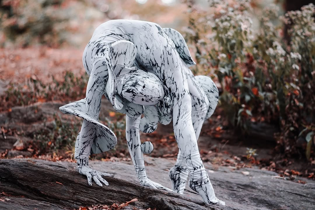 Two people in Mushroom Fungus Costumes perform an intertwined pose on a rock outdoors, showcasing futuristic fashion and exotic dance wear perfect for Burning Man and artistic events.
