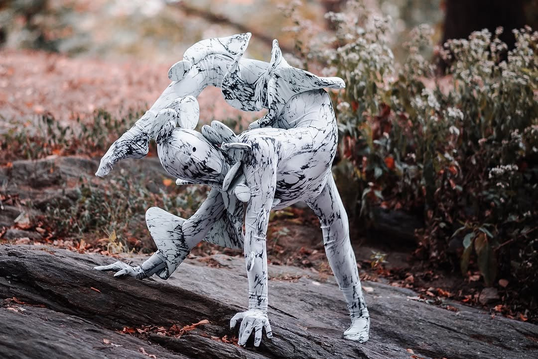 Two people in Mushroom fungus Costumes perform an acrobatic pose on rocks in a park, showcasing this futuristic, trending artistic outfit—perfect for exotic dance, Burning Man, or a unique Halloween look.