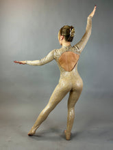 Model wears the Champagne Fairy Sequin Catsuit with open back, turtleneck, and sleeves, posing with arms outstretched against a plain gray background.