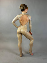 A person in the Champagne Fairy Sequin Catsuit with turtleneck, open back, and sleeves poses against a plain gray background—the sparkling design is perfect for a standout performance costume.
