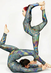 Two performers in Iridescent Black Catsuit Jumpsuits with full sleeves and turtlenecks strike acrobatic poses against a plain white background.