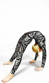 A woman in a Jester Print Catsuit Full Body Costume, a colorful spandex jumpsuit with headpiece, gloves, and socks in UV glow fabric, does a backbend against a white background, evoking a vibrant dance performance.