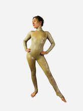 Wearing the Champagne Fairy Sequin Catsuit with open back, turtleneck, and sleeves, a person strikes a pose with hands on hips against a white background.