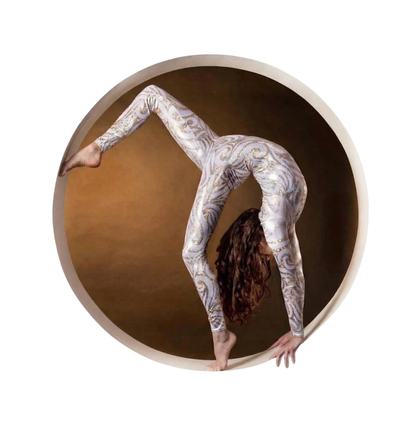 A woman wearing a White and Gold Catsuit Bodysuit with full sleeves and a round neck does a handstand in a circular frame against a brown background.