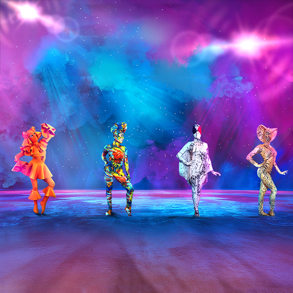 Four figures in colorful, abstract costumes pose on a surreal, vibrant stage with bright lights and a starry sky.