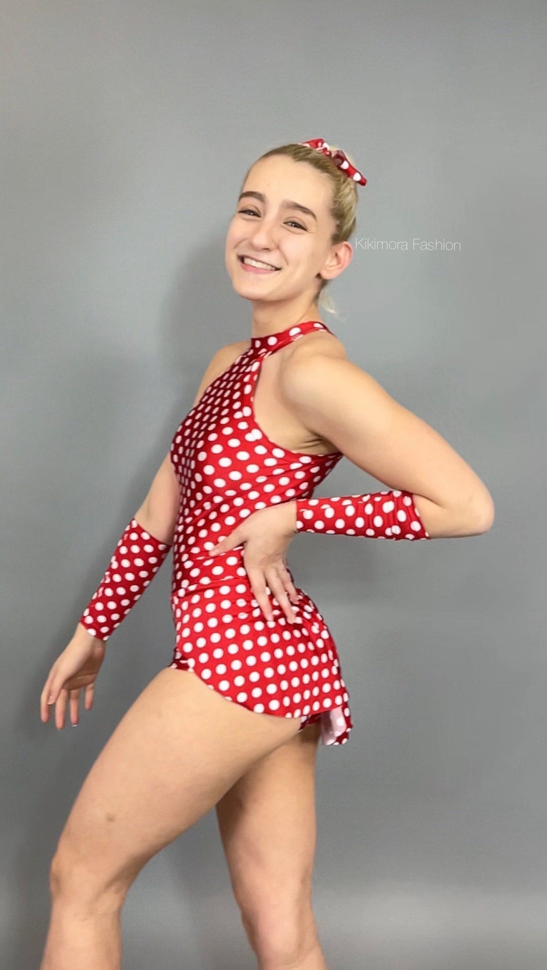 A smiling person poses confidently against a gray background, showcasing the Exotic Dance Wear super cute burlesque bodysuit with skirt that highlights playful allure in dance wear.