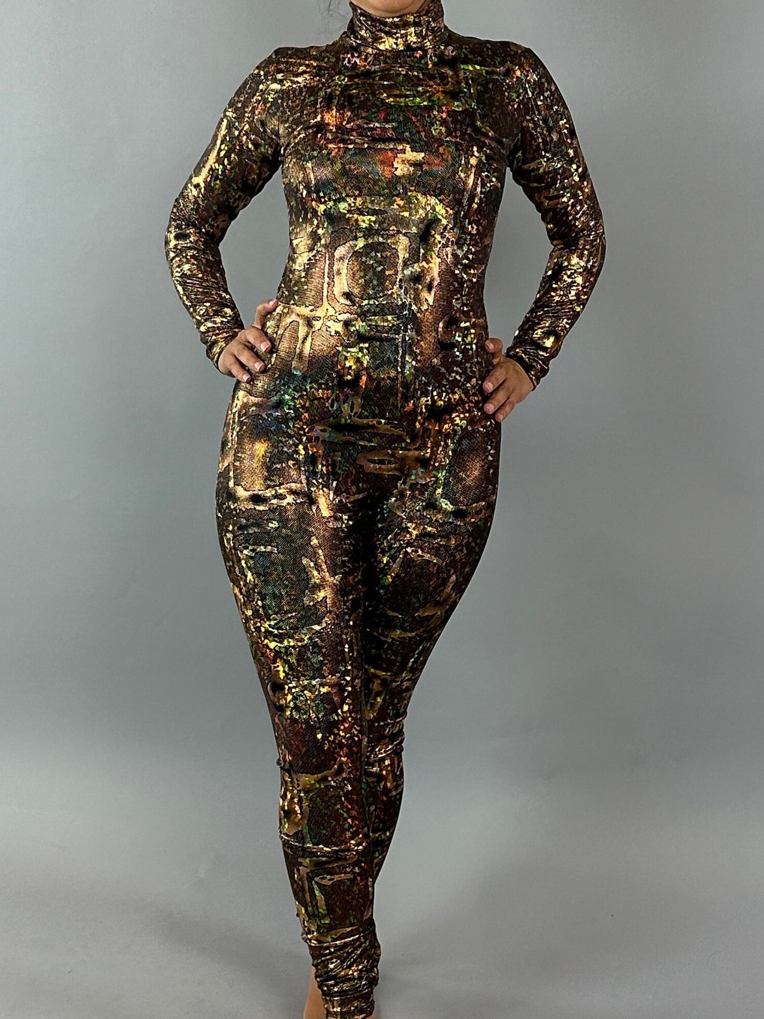 A person wearing an Alien Costume, an exotic dance wear Lycra jumpsuit available for women or men, featuring a multicolored customizable design, stands against a plain gray background.