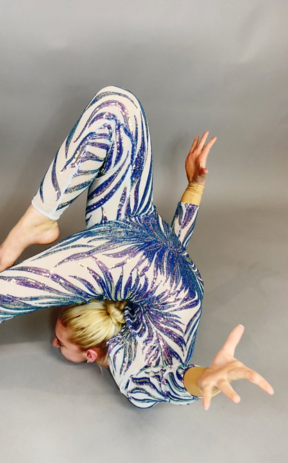 A contortionist poses gracefully in a Black and Red Floral Sequins Catsuit with full sleeves, showing off the tear drop back opening against a neutral background.