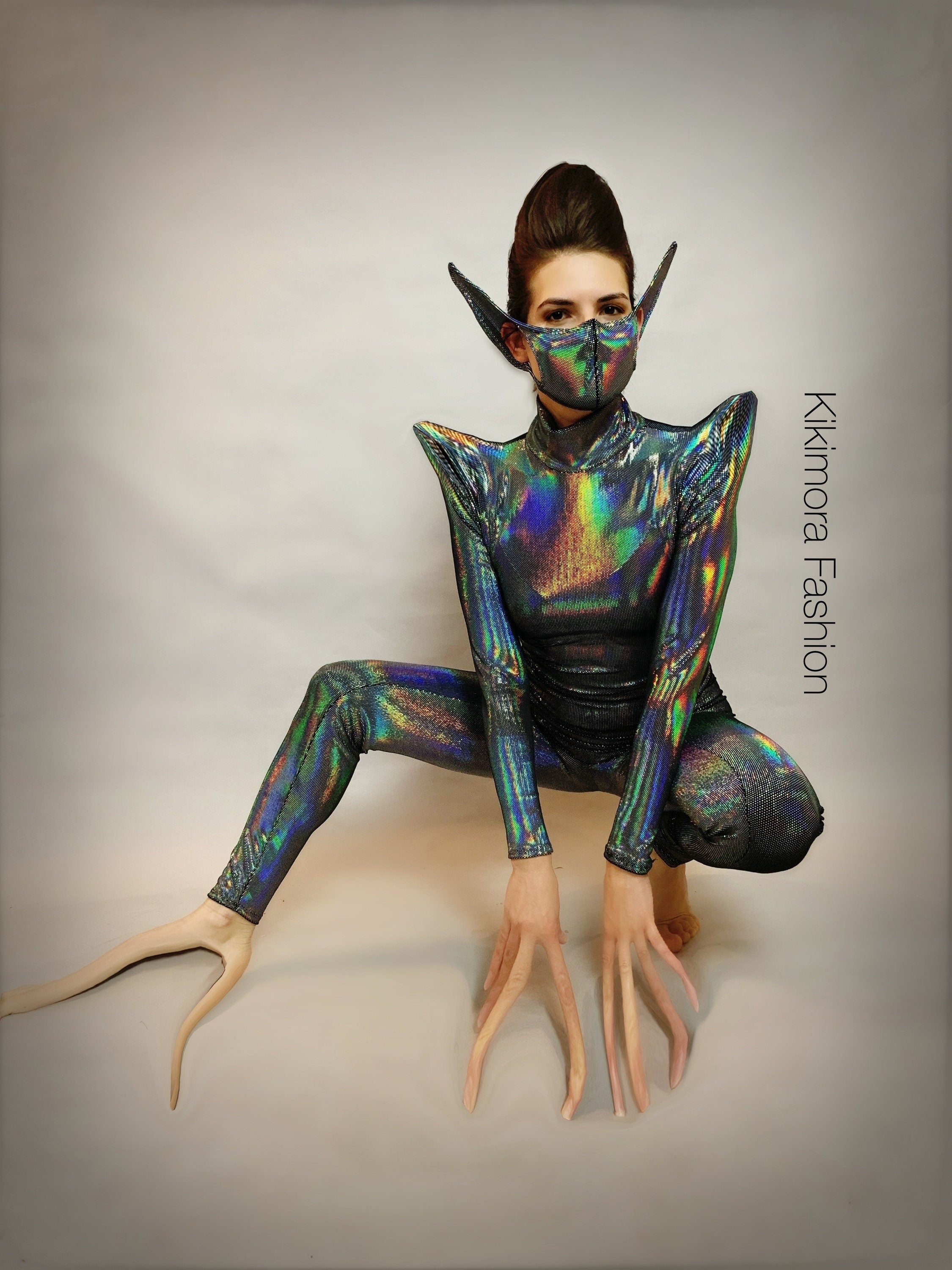 Person in an iridescent bodysuit with exaggerated gloves, pointy ears, and the Elf Ears Face Mask for All Ages—an avant-garde look inspired by Kikimora Fashion.